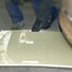 Eine Person schiebt in einer Halle eine secutex-Wendematte unter ein Maschinenbauteil