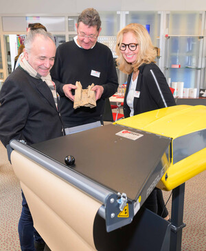 Verpackungs-Expertin demonstriert zwei Gästen die Papierpolstermaschine PaperJet®