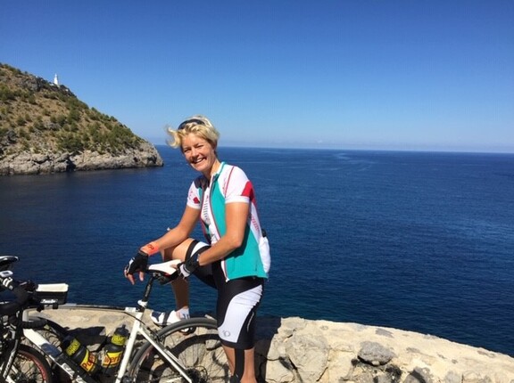 Julia Steiner mit ihrem Fahrrad an einer Klippe mit dem Meer im Hintergrund
