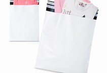 Coex-Versandtaschen gefüllt mit Kleidungsstücken auf weißem Hintergrund