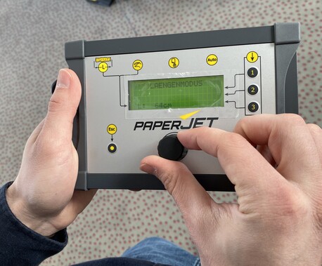 Eine Person dreht einen Knopf am Bedienelement des PaperJets und wählt zwischen den verschiedenen Funktionen